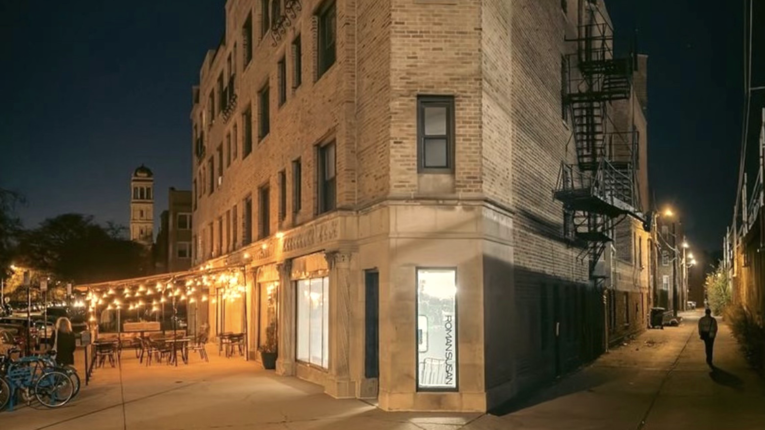The flatiron building at night with string lights outside Archie's Cafe